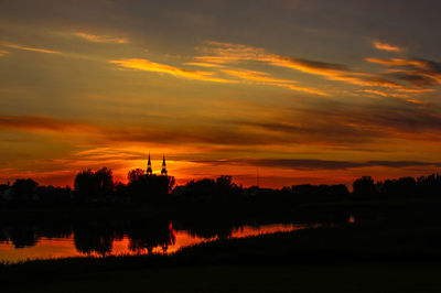 Scenic view of lake against orange sky