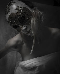 Portrait of woman wearing mask in darkroom