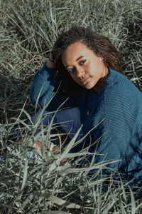 Portrait of young woman lying on field