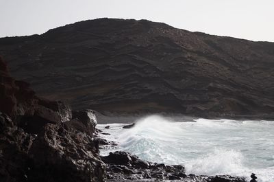 Scenic view of sea and mountains against sky