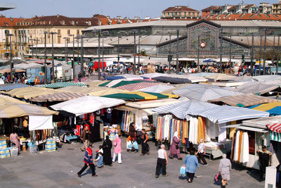 Group of people in market against buildings in city