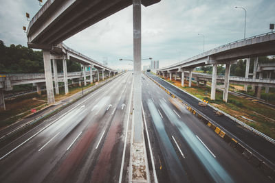 Blurred motion of vehicles on multiple lane highway below bridge