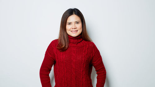 Portrait of smiling young woman against white background