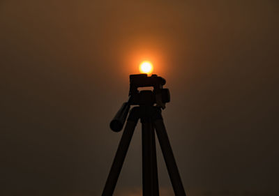 Close-up of illuminated lamp against sky at sunset