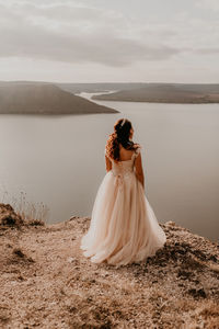 Rear view of woman looking at sea against sky