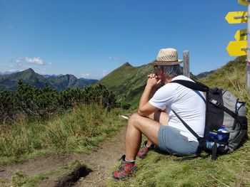 Man with arms outstretched against mountain range