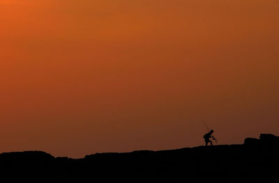 Silhouette man against clear sky during sunset