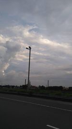 Empty road against cloudy sky