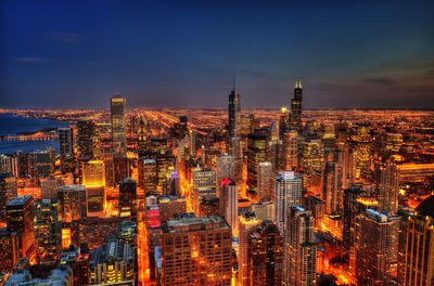 Illuminated city against sky at dusk