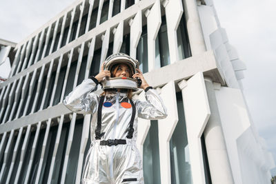 Astronaut wearing space helmet in front of building