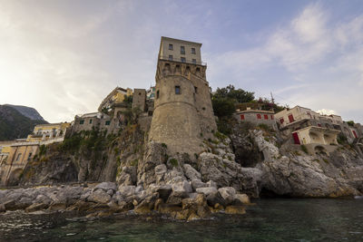 Historic building by rocks against sky