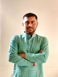 Portrait of young man standing against gray background