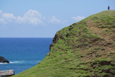 Scenic view of sea by cliff against sky