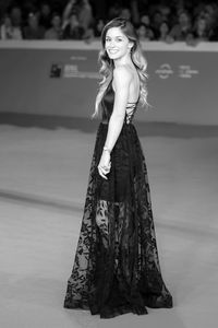 Portrait of beautiful young woman standing against wall