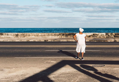 Full length rear view of man walking on beach