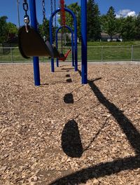 Shadow of swing hanging on playground