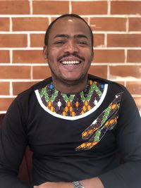 Portrait of smiling young man against wall