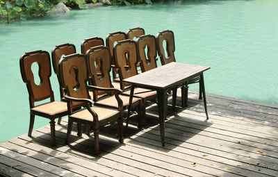 High angle view of empty chairs on table by sea