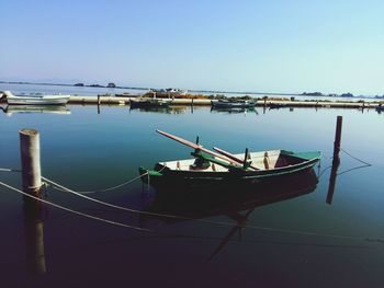 Boats moored on sea against clear sky