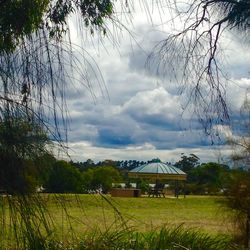 Scenic view of grassy field against cloudy sky