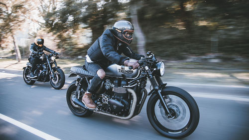 People riding motorcycle on road