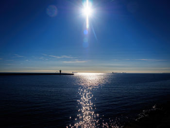 Scenic view of sea against bright sun