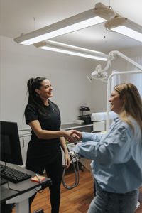 Female dentist greeting patient in office