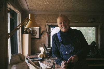 Portrait of smiling gay man in workshop