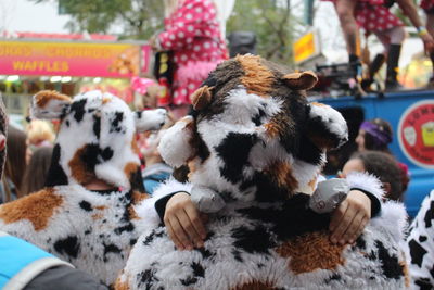 Rear view of father in cow costume carrying son during carnival