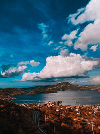 Aerial view of sea and cityscape against sky