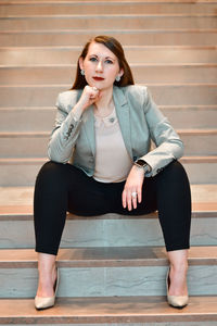 Portrait of young woman sitting on staircase