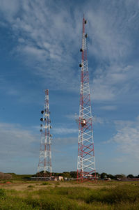 Low angle view of communications tower on field against sky