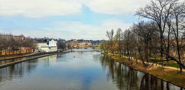 Scenic view of river by buildings against sky