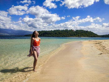 Full length of man standing on beach against sky