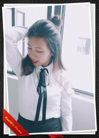 Young woman looking through window