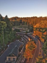 High angle view of road amidst trees against clear sky