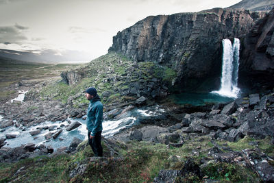 Rear view of man on mountain against sky