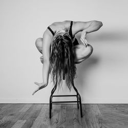 Naked woman standing against wall