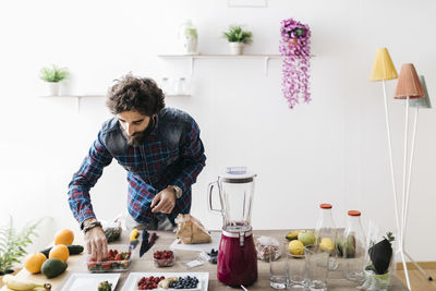 Young man preparing food on table at home