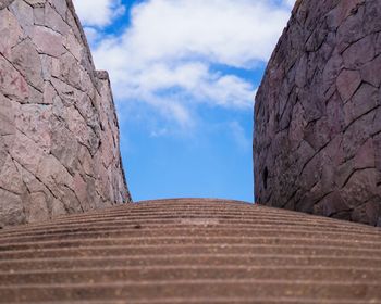 Low angle view of stone wall against sky