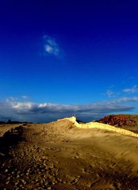 Scenic view of beach against blue sky