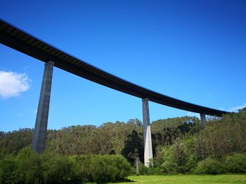 Low angle view of bridge against clear blue sky