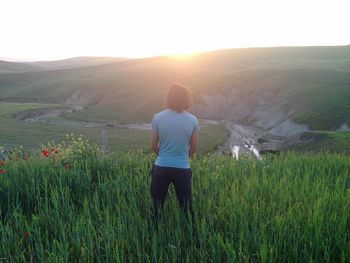 Rear view of woman standing on field