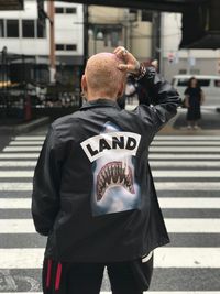 Rear view of man crossing road