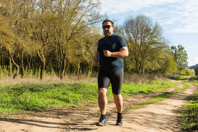 Full length of a man jumping on dirt road