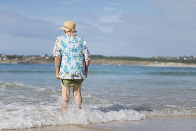 Back view of senior woman at seashore