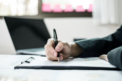 Midsection of businessman working on table