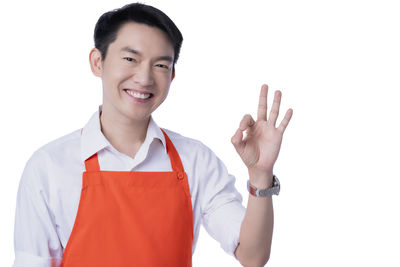 Portrait of smiling man standing against white background