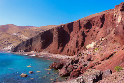 Scenic view of rocks and mountains against clear blue sky