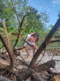 Full length of woman on tree in forest